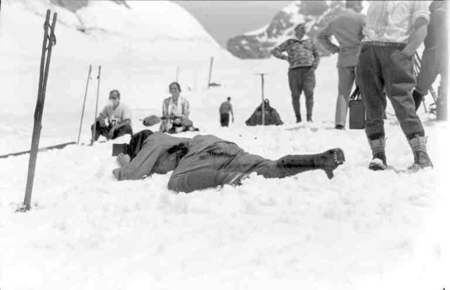 Wintersport am Jungfraujoch: Fotograf auf dem Bauch im Schnee während dem Rennen