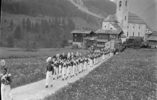 Prozession in der Kippel (Wallis): Auszug aus der Kirche, Militär und Pater