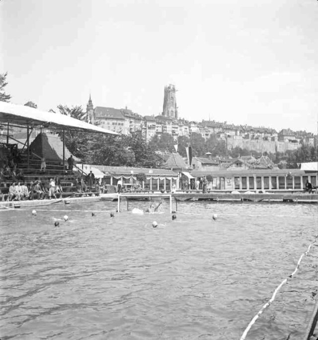 Wettschwimmen, Freiburg  i.Üe., Schwimmbad La Motta, im Hintergrund Turm der Kathedrale Sankt Nikolaus (Cathédrale de Saint-Nicolas)