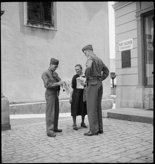 R543: Zwei Soldaten und Frau mit Zeitung in der Hand