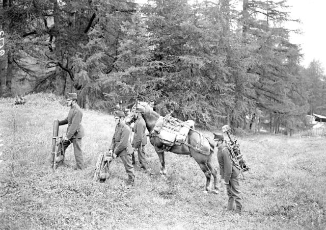 Die Lasten eines Maschinengewehrs werden vom Pferd auf die Soldaten verteilt