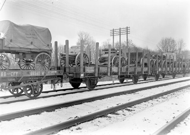 Auf der Eisenbahn verladene Geschütze und Materialwagen