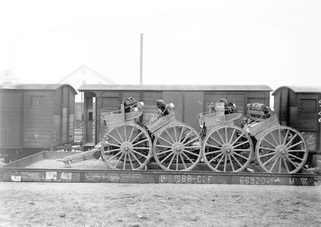 Vier Munitionswagen auf einem Eisenbahnwagen verladen