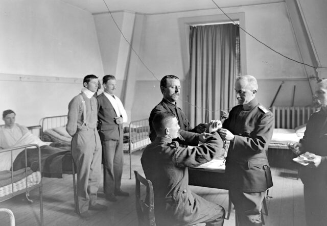 Behandlung eines Patienten durch Major Varmod im Krankenzimmer des Armeestabes