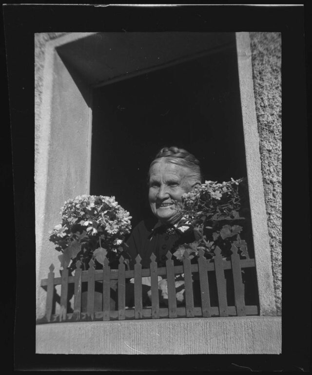 Alte Frau in Wabern am Fenster