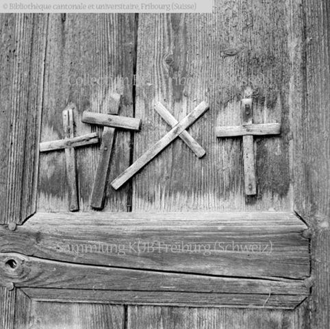 Glâne, Romont: poya sur le linteau de porte d'une grange et croix de bois