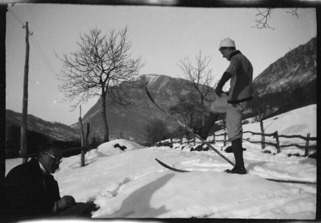 Josef Tcherv à ski et William Ritter dessinant étendu dans la neige