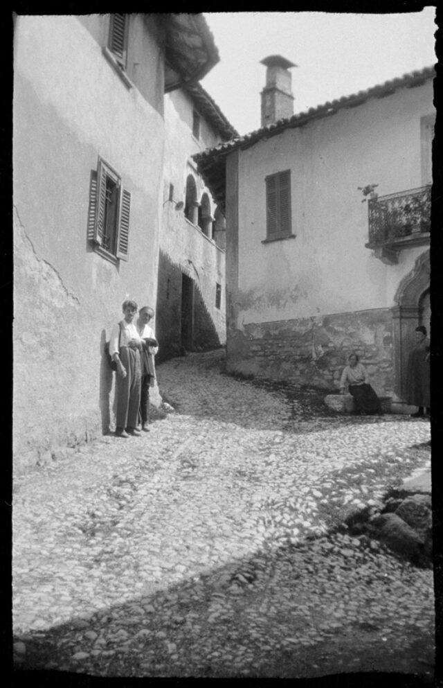 William Ritter et Janko Cadra dans la ruelle d'un village tessinois, sous le regard de deux habitantes