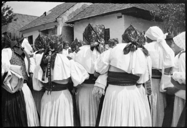 Femmes de dos, en costumes traditionnels slovaques, sur la place d'un village