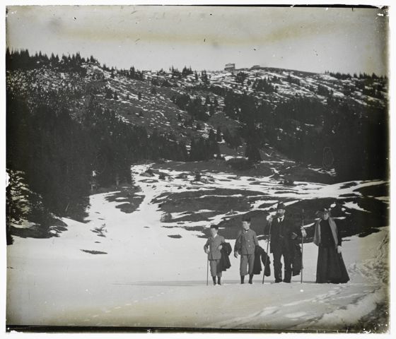 Eine Familie vor einem leicht verschneiten Berghang