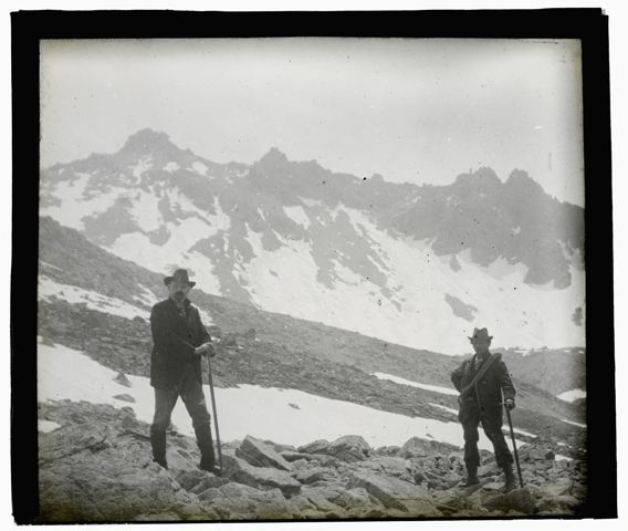 Zwei Bergsteiger vor einem markanten Berggipfel