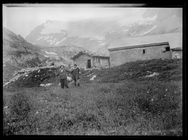 Zwei Bergsteiger vor Hütten