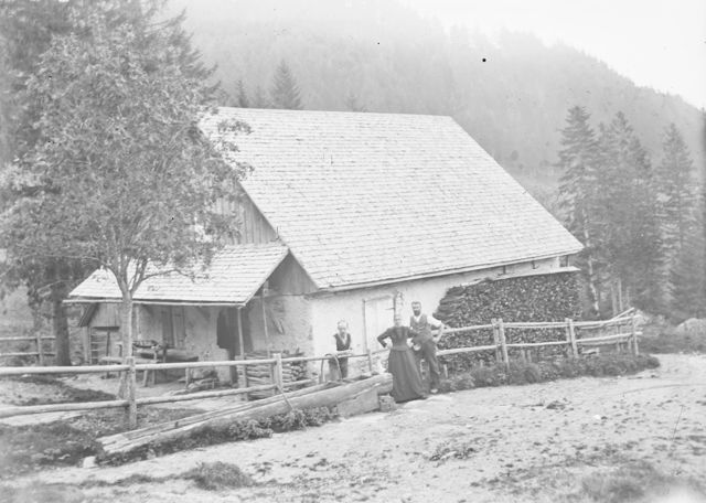 Drei Personen vor einem Haus