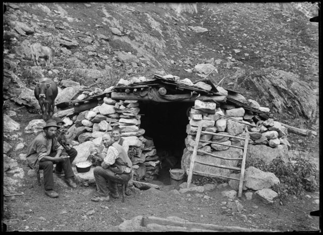 Montagnards devant un abri en pierre