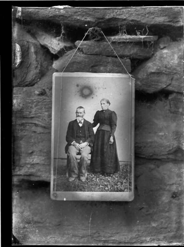 Fotografia di una fotografia di una coppia, appesa ad un muro all'aperto