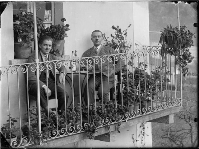 Giovanni Bozzini e Corazzini seduti a un tavolo su un balcone a Comprovasco