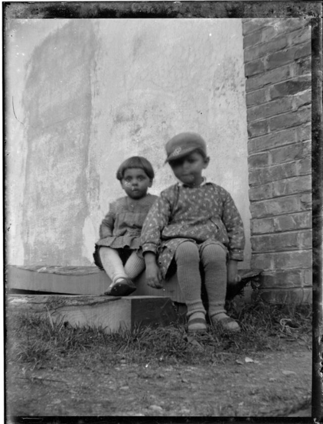 Due bambini seduti davanti a un edificio