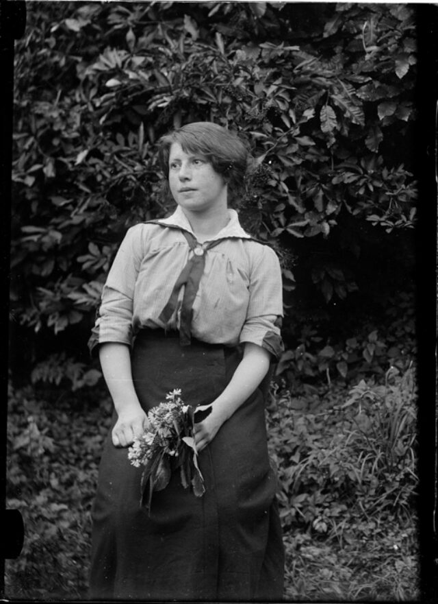 Giovane donna in giardino con un mazzo di fiori