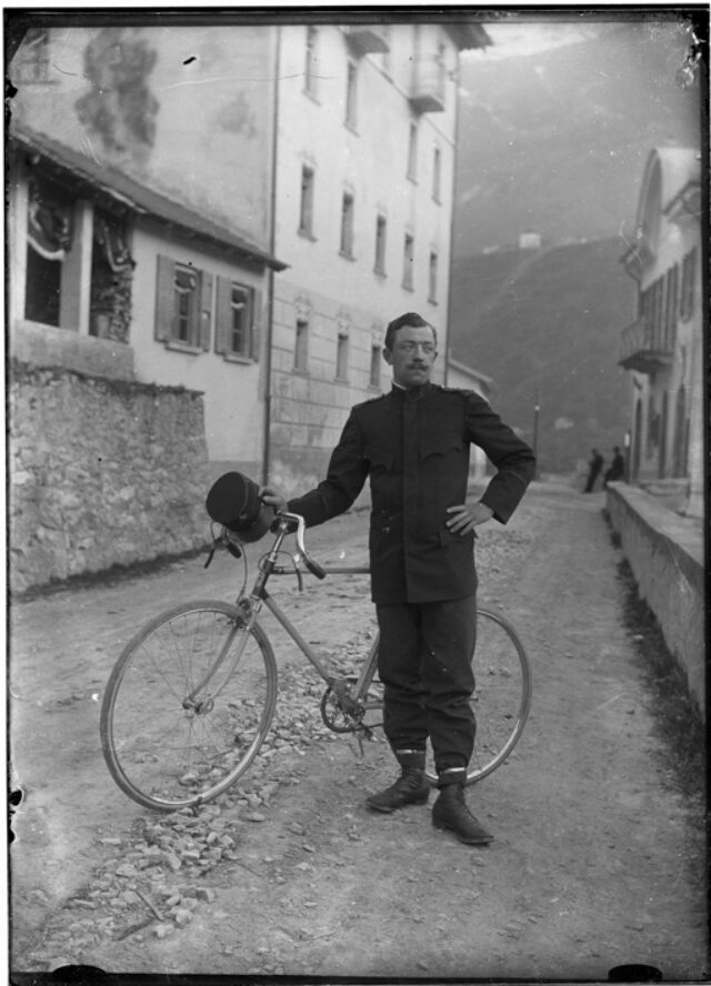 Uomo in divisa con bicicletta in una strada