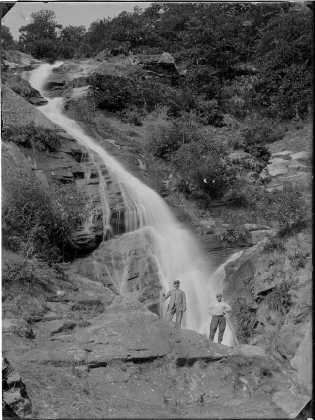 Due uomini in piedi davanti alla cascata del Luinasco