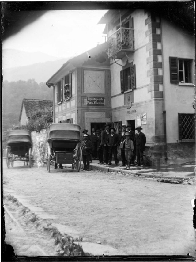 Carrozze e gruppo di uomini davanti a un edificio pubblico a Ponto Valentino