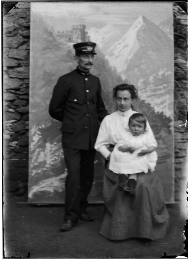 Agostino, in divisa da ferroviere, ed Elisa Monico-Gianella con la figlia Emma davanti a un fondale
