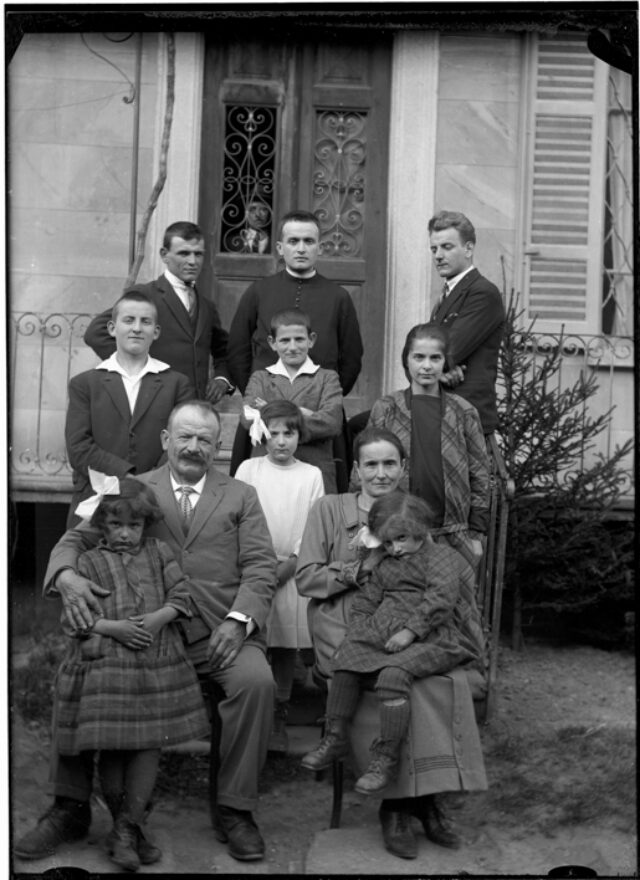 Famiglia Monico davanti a una casa; Dietro da sinistra: Sebastiano, Bruno e Eli; in mezzo: Fausto, Dazio e Silvia; davanti: Aldina, Sebastiano (padre), Francesca, Gabriella (madre) e Verena