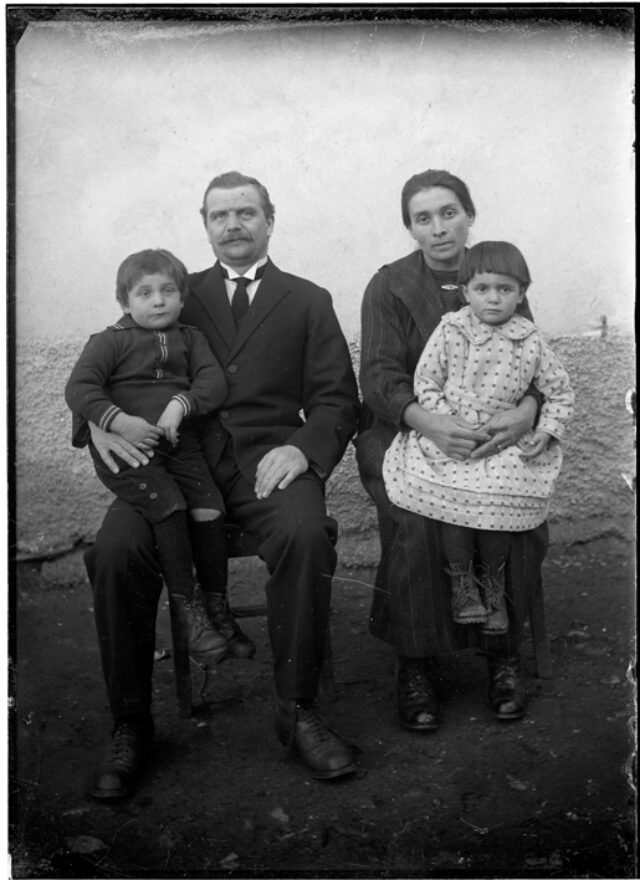 Martino e Ambrosina Frusetta con i figli Aldo e Celsina seduti davanti a un muro