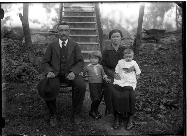 Martino e Elena Jemini con i figli Ugo e Franco davanti alla scala esterna di una casa