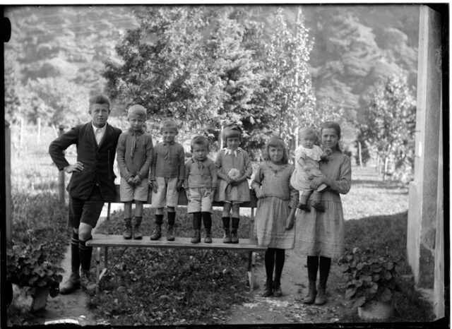 Otto figli della famiglia Veglio nel giardino di una casa a Comprovasco