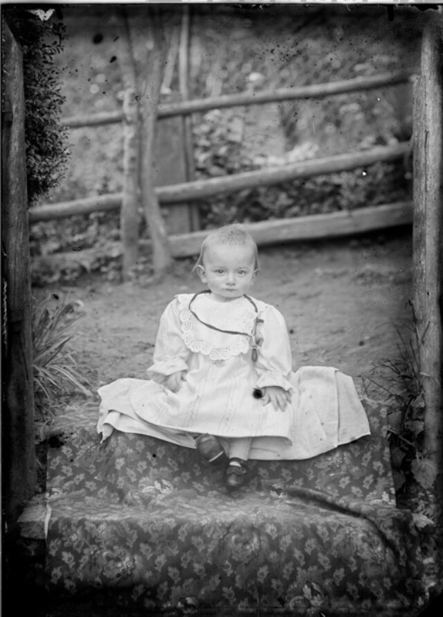 Bambina seduta su un tappeto in giardino