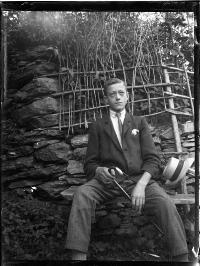 Saul Donetta, figlio del fotografo, seduto su una panca all'aperto