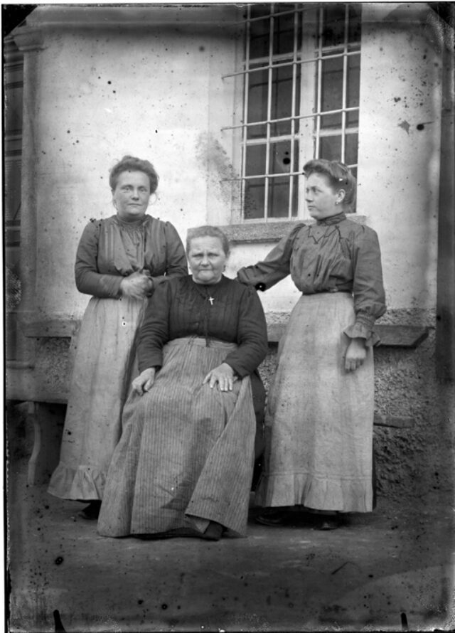Maria, Agostina e Mariin Bozzini davanti a una casa