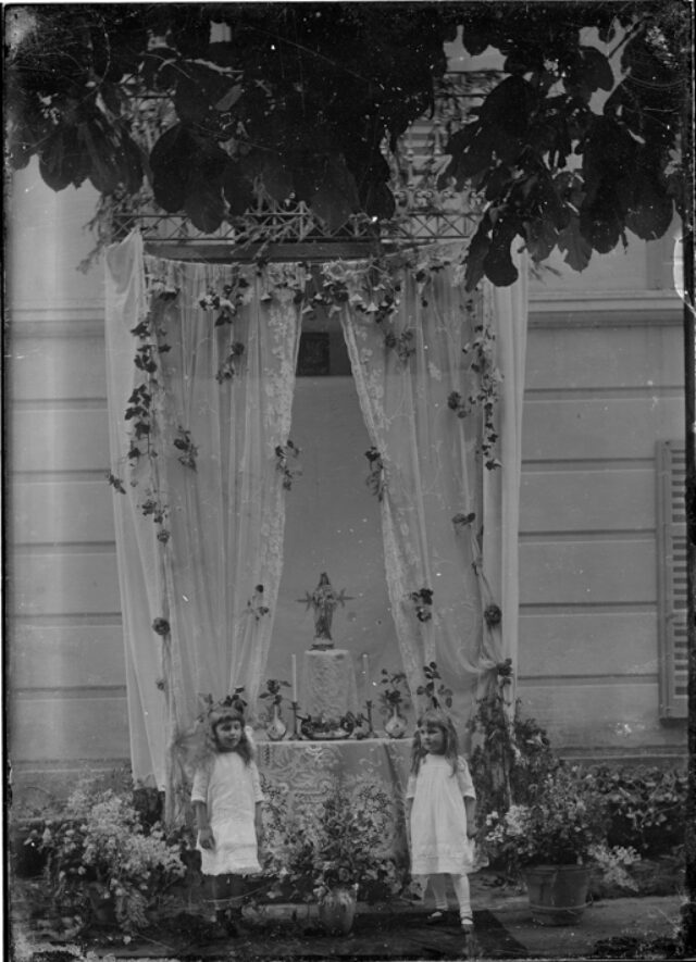 Due bambine davanti a un altare all'aperto, davanti a una casa, probabilmente per la festa della Madonna di Aquila