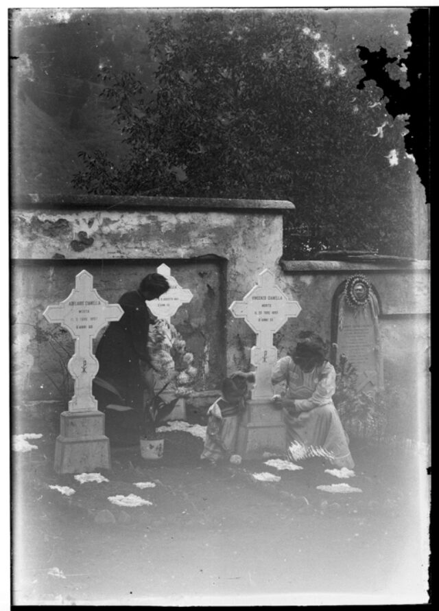 Due donne e una bambina attorno alle tombe della famiglia Gianella nel cimitero di Comprovasco