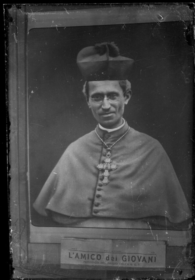 Fotografia del ritratto di un vescovo; sulla cornice un foglio con la scritta: "l'amico dei giovani"