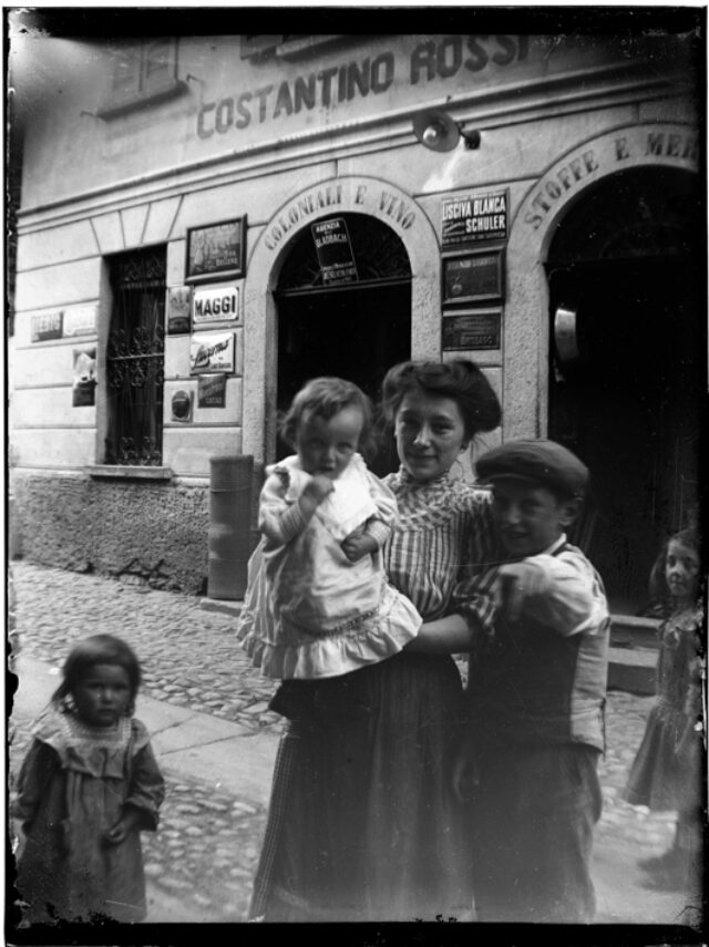 Donna con bambini davanti al negozio di Costantino Rossi