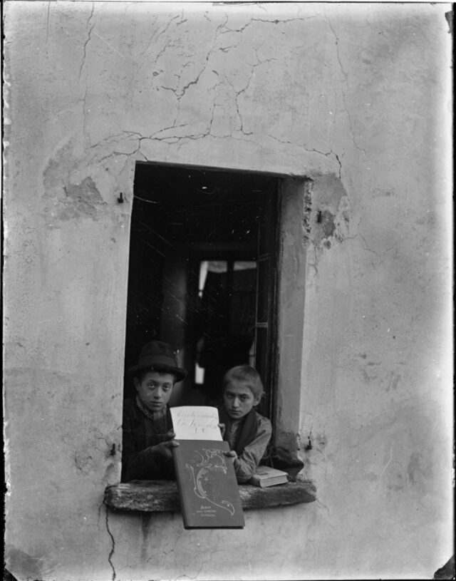 Figli di R. Donetta alla finestra della Casa Rotonda a Casserio con un libro in mano