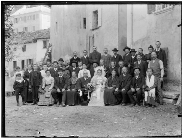 Gruppo di persone davanti a un edificio nella piazza di Malvaglia in occasione di un matrimonio