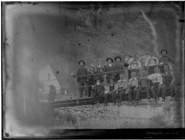 Gruppo di uomini e ragazzi sul ponte sul fiume Dongia a Motto