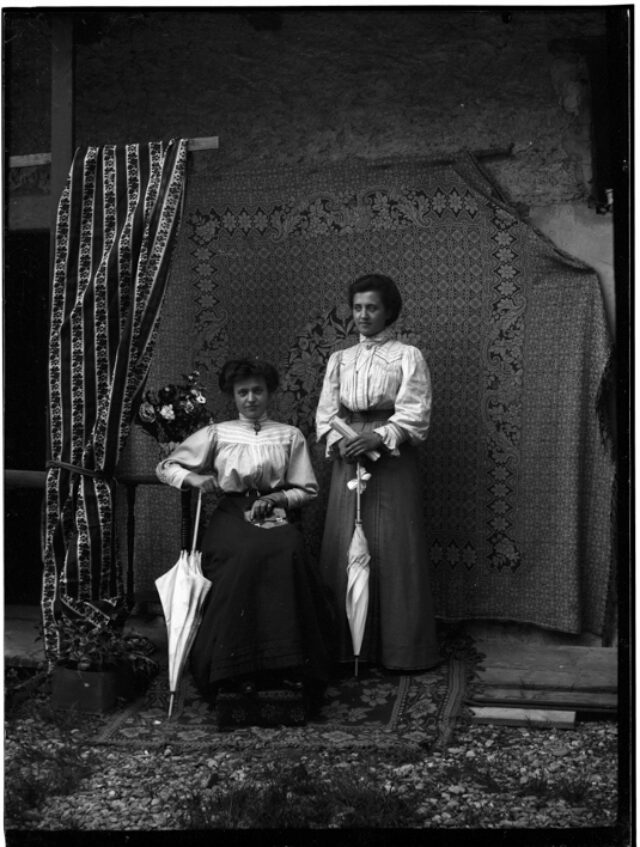 Due sorelle Donetta in posa davanti a un fondale con motivo floreale