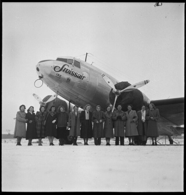 [12 angehende Stewardessen posieren vor einer DC-3]