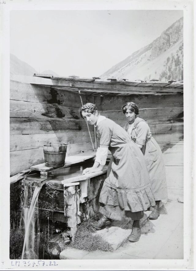 [Zwei junge Frauen am Brunnen aus Holz am Waschen]