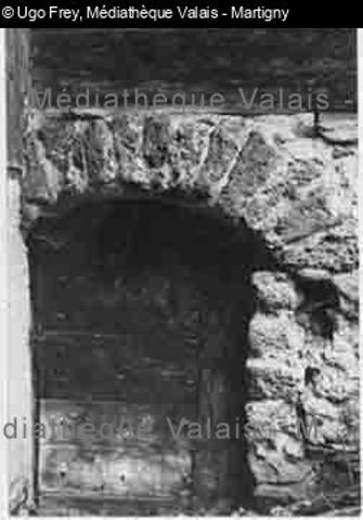 Porte de cave cloutée de bois, arc en maçonnerie en tuf,Hte-Nendaz