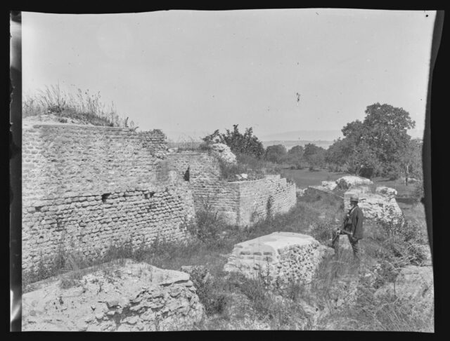 Avenches, théâtre romain. Un homme pose à côté des murs Est, vus depuis le sud-est.