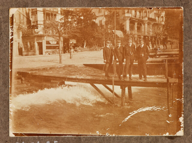 Vier Männer am Quai (Brunnen?) auf Steg, Föhnsturm