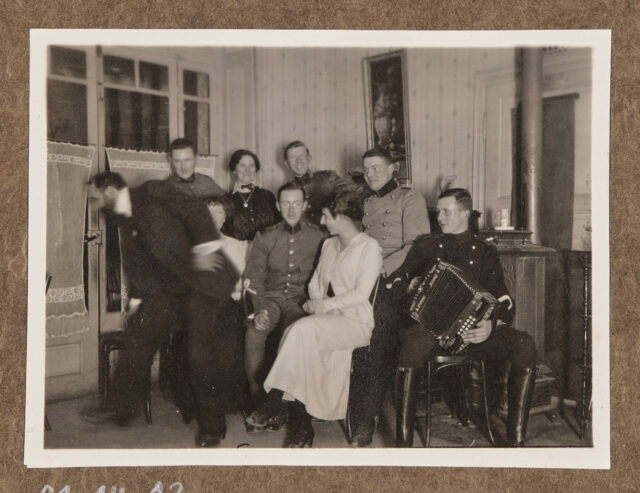Gruppe mit Ziehharmonikaspieler und Dame in weissem Kleid, Inglin in der Mitte
