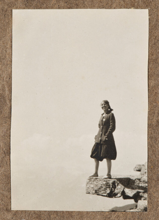Dame mit Kopftuch auf Felsvorsprung