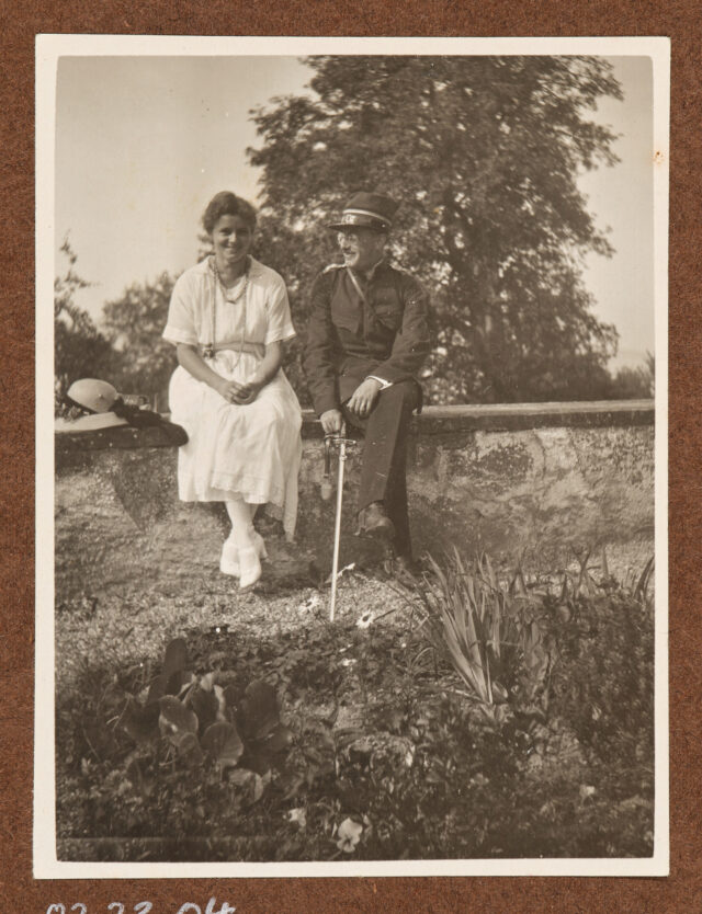 Inglin (in Uniform) mit Bettina Zweifel auf einer Mauer sitzend