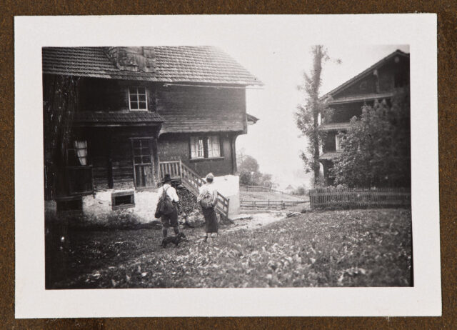 Meinrad Inglin und Bettina Zweifel (?) mit Hund zwischen zwei Häusern in Muotathal